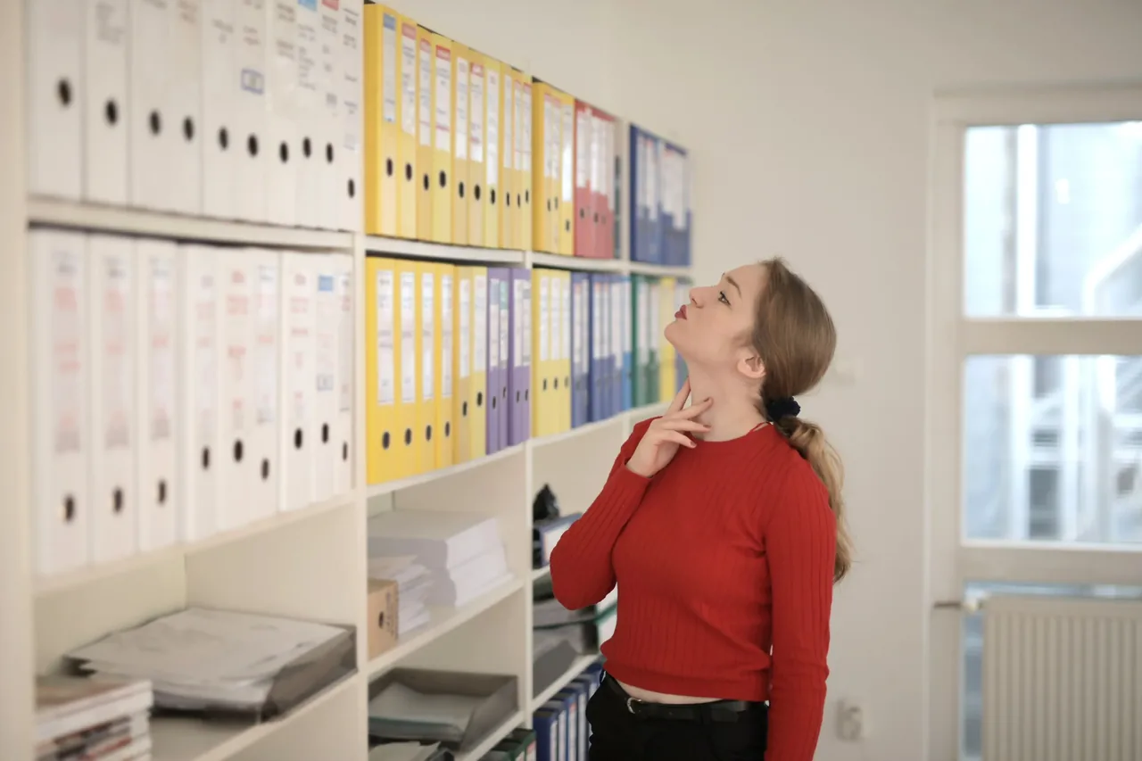 Professionista consulta raccoglitori in un archivio