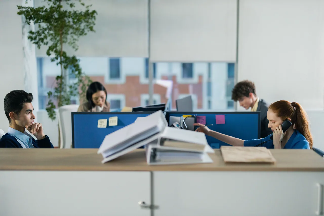 Persone al lavoro con documenti e computer in un ufficio